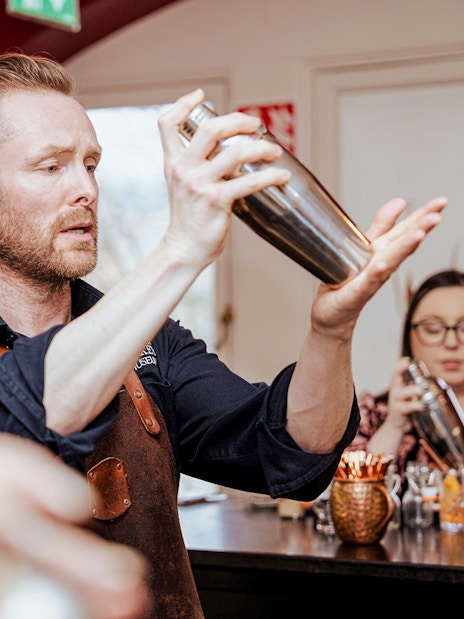 Bartender demonstrating cocktail shaking at the Irish Whiskey Museum masterclass.