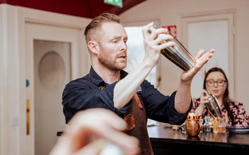 Bartender demonstrating cocktail shaking at the Irish Whiskey Museum masterclass.