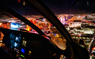 Helicopter view of Las Vegas Strip at night with illuminated hotels and casinos.
