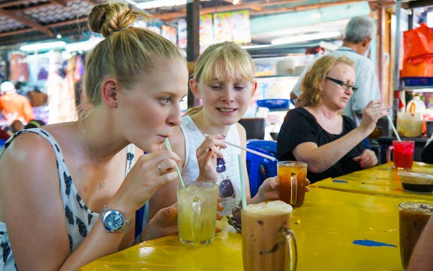 Street food vendor preparing traditional Malaysian dishes in Kuala Lumpur during Flavours of Malaysia food tour.