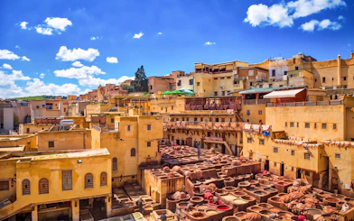 Chouara Tannery in Fes Medina with traditional dyeing vats under a clear sky.