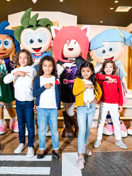 Children posing with KidZania mascots in Dubai.