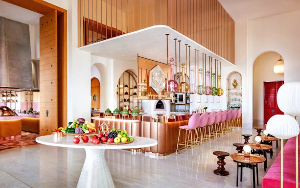 Dining area of Arianas Persian Kitchen with colorful decor and fresh produce display.