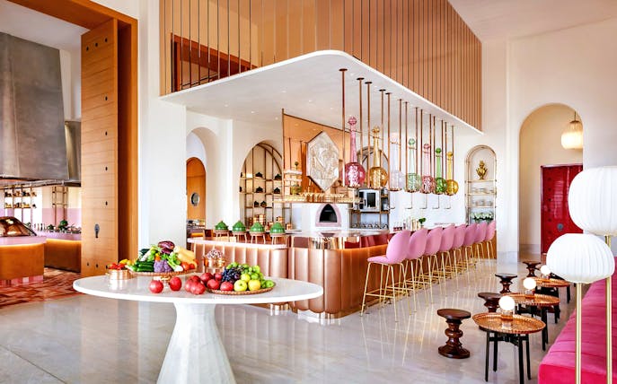 Dining area of Arianas Persian Kitchen with colorful decor and fresh produce display.