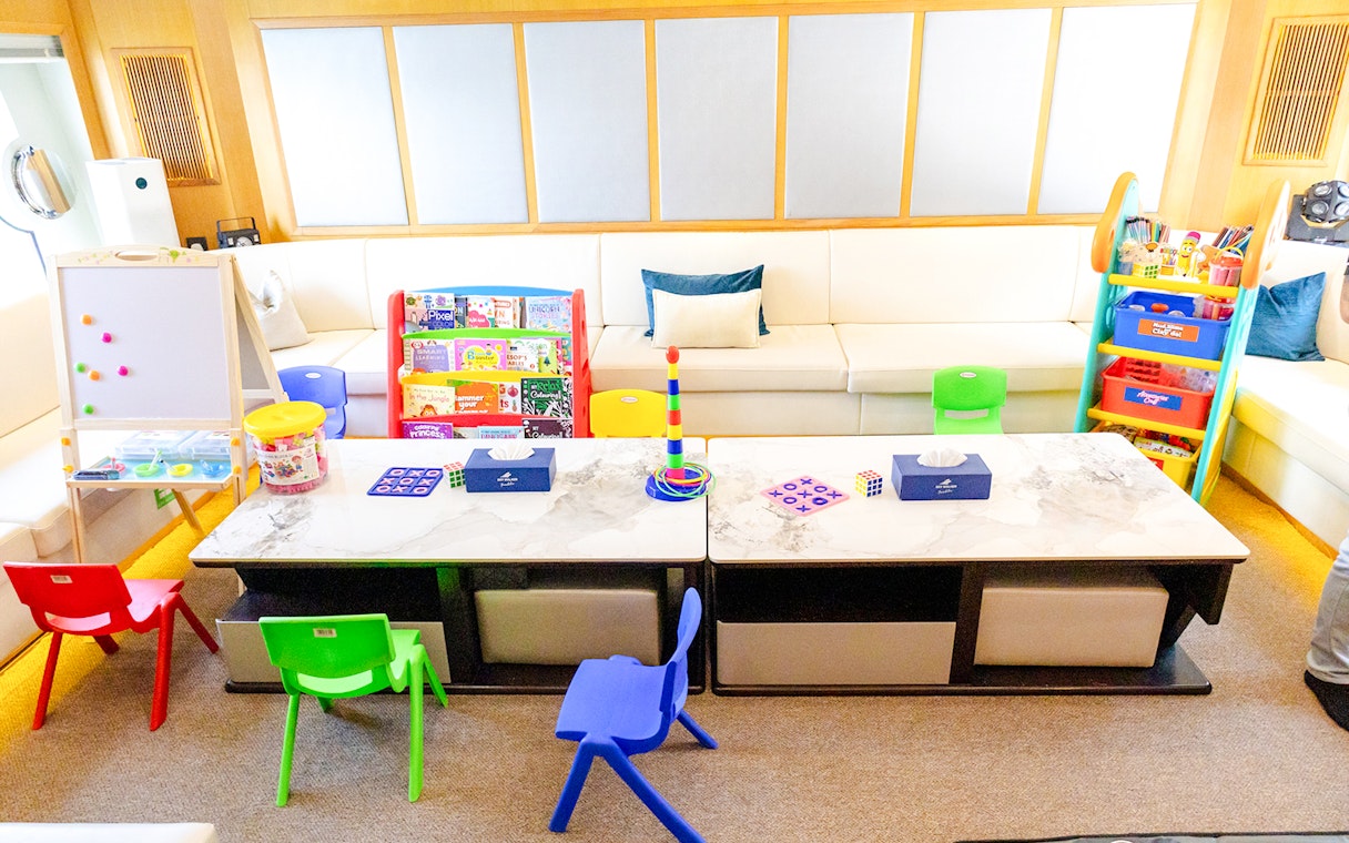 Children's play area with toys and books inside a yacht's interior.