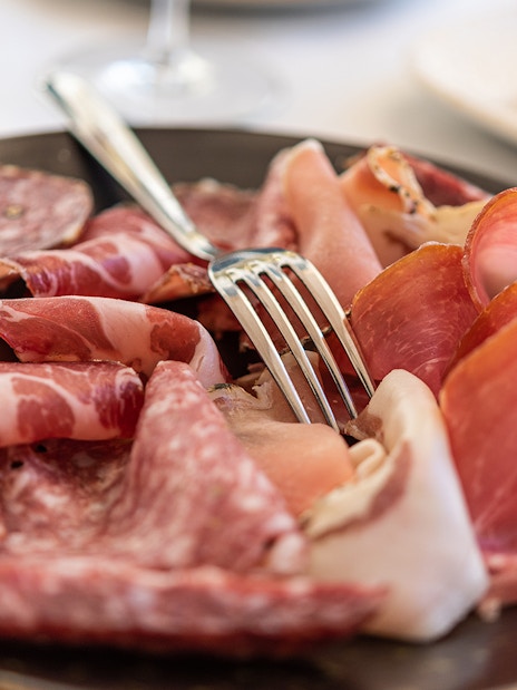 Italian cured meats platter with fork on a Food & Wine Tour in Rome.