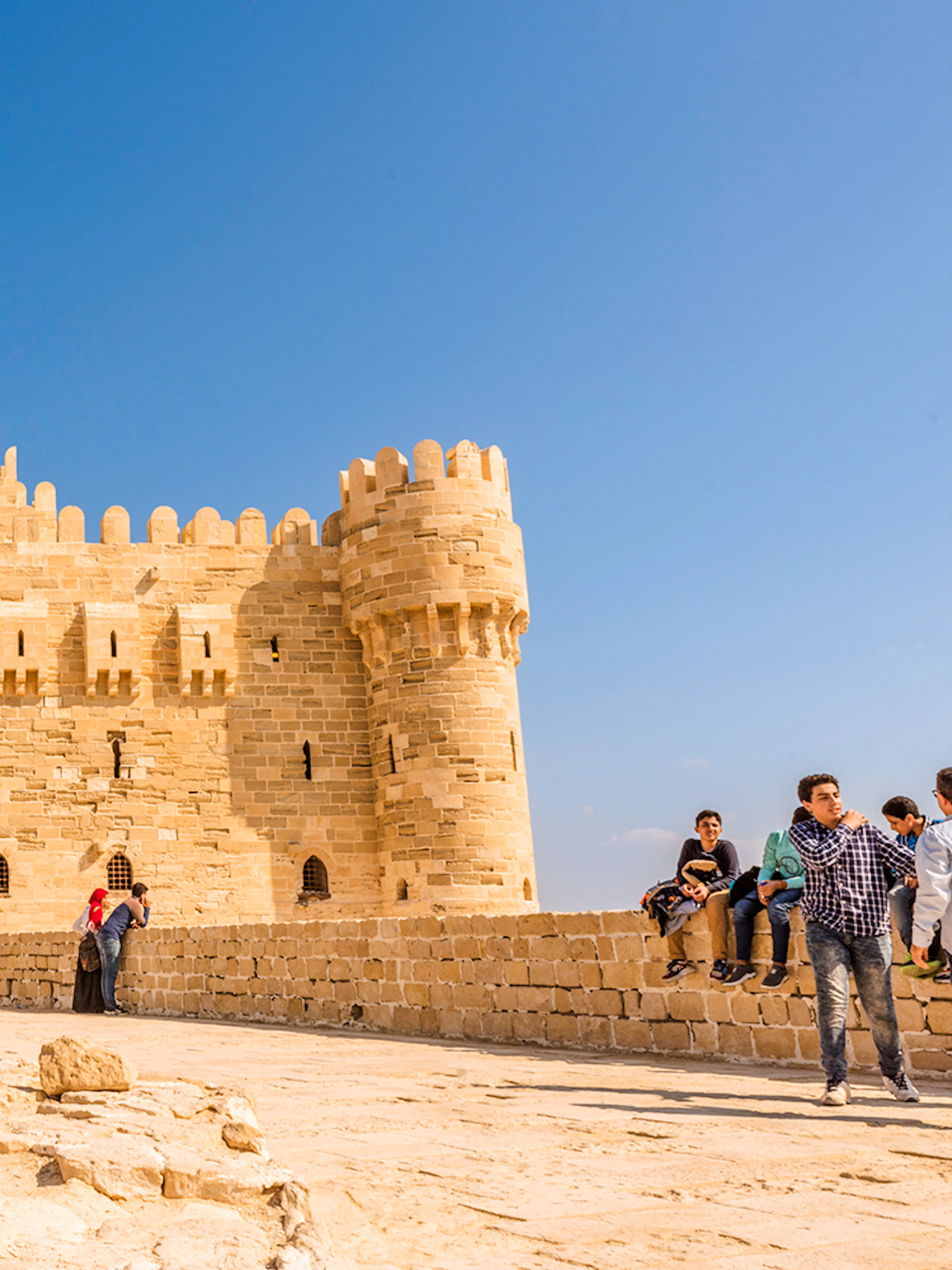 Citadel of Qaitbay in Alexandria with tourists exploring the historic site.