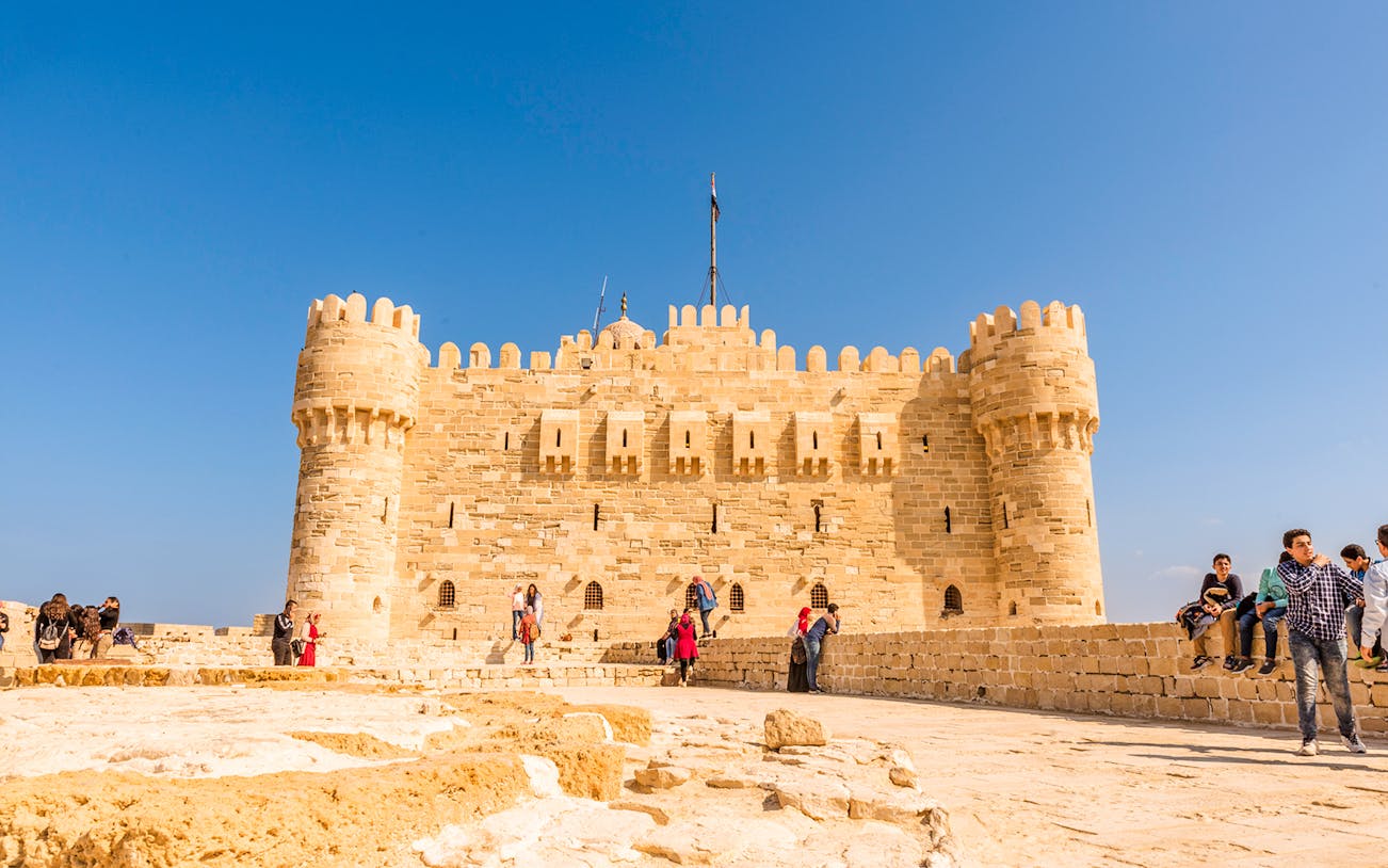 Citadel of Qaitbay in Alexandria with tourists exploring the historic site.