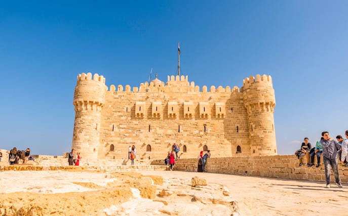 Citadel of Qaitbay in Alexandria with tourists exploring the historic site.