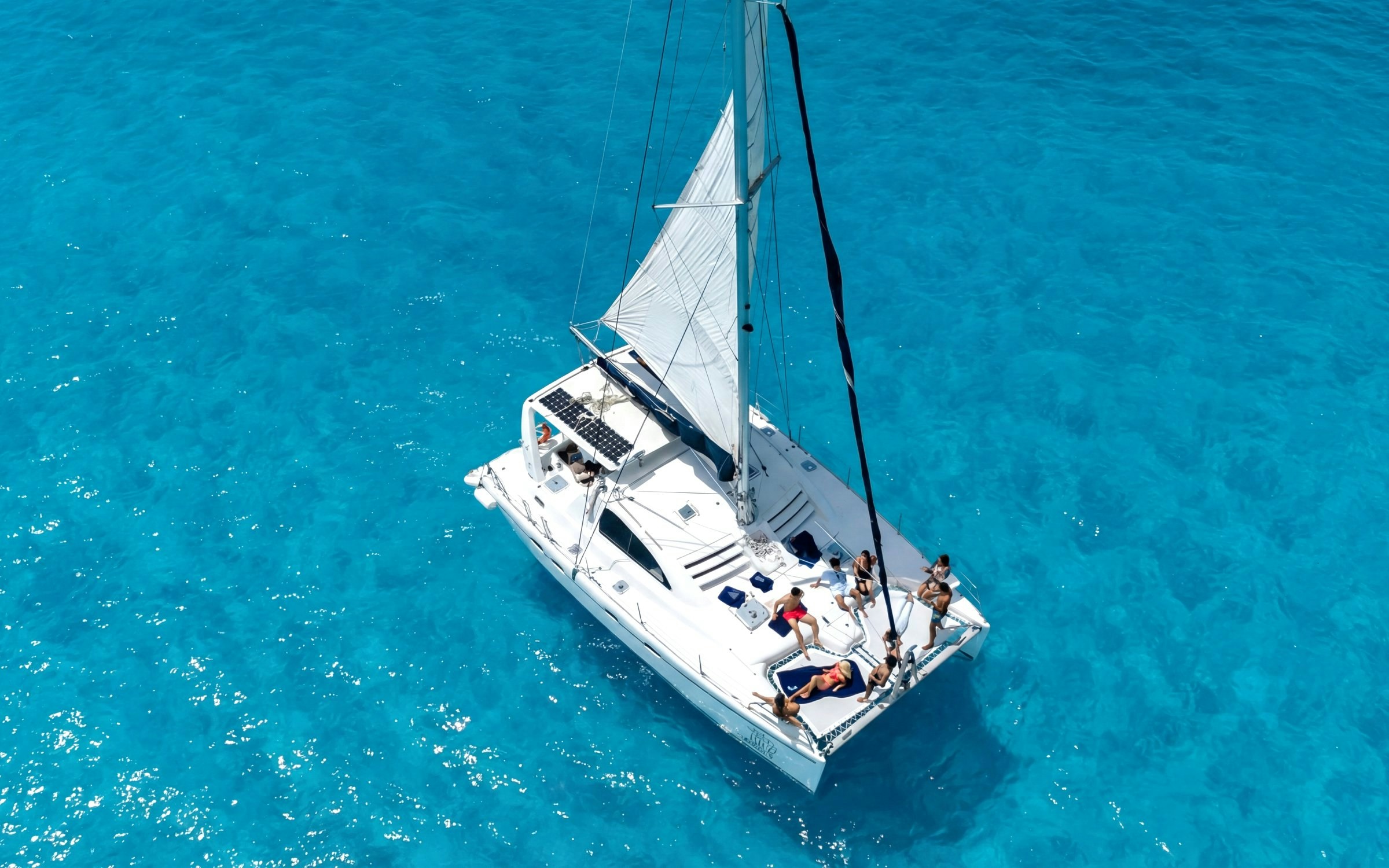 Catamaran sailing on clear blue waters near Isla Mujeres.