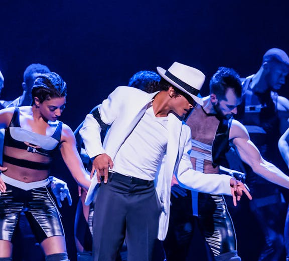 Dancers performing on stage in a jukebox musical show.