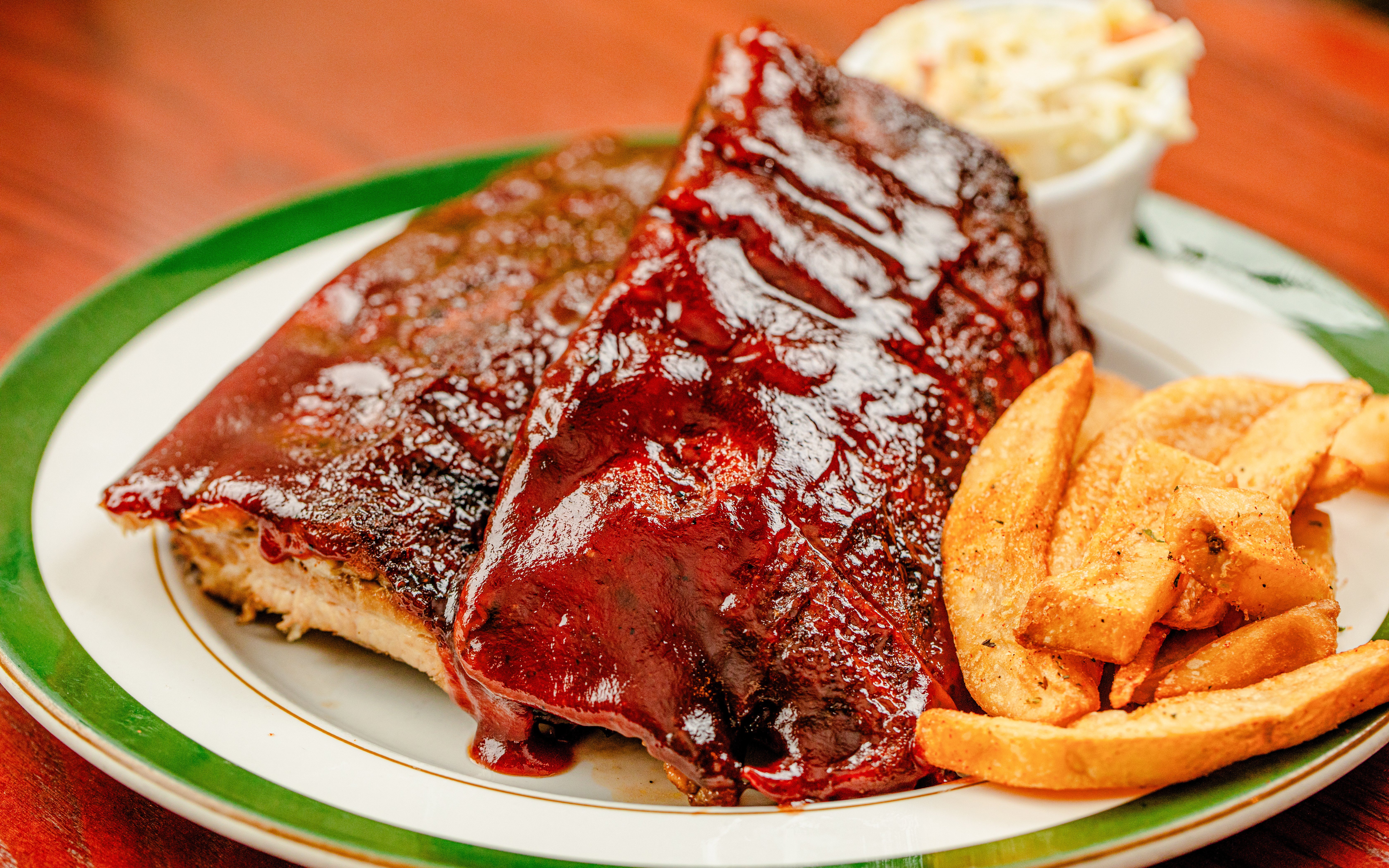 Barbecue ribs with fries and coleslaw on a plate, Parisian food experience.