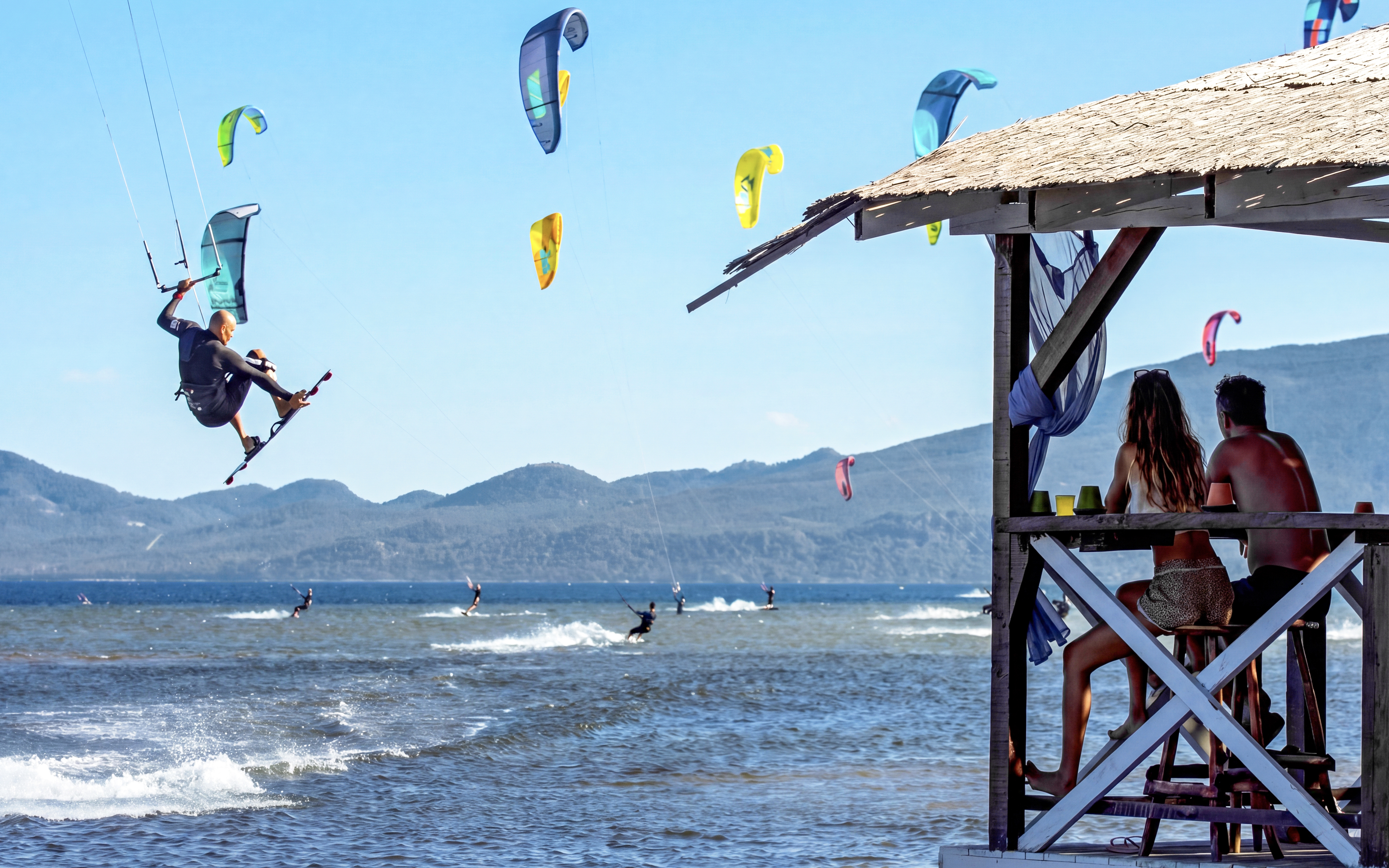 Kiteboarders at Delta Neretva, Croatia with mountains in the background.