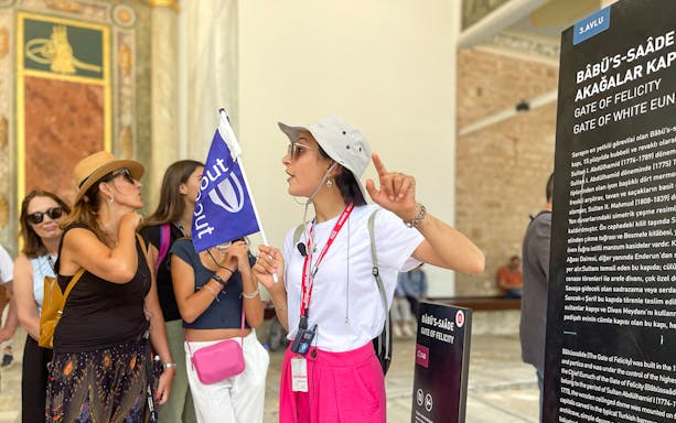 Tour guide leading a Spanish tour at Topkapi Palace's Gate of Felicity.