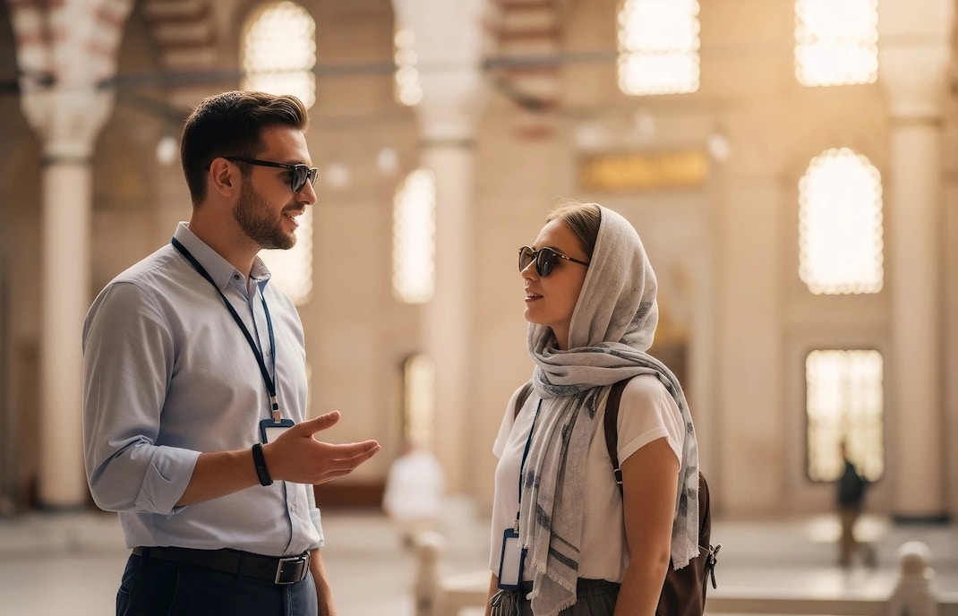 Tour guide speaking with woman tourist inside Suleymaniye Mosque, Istanbul.