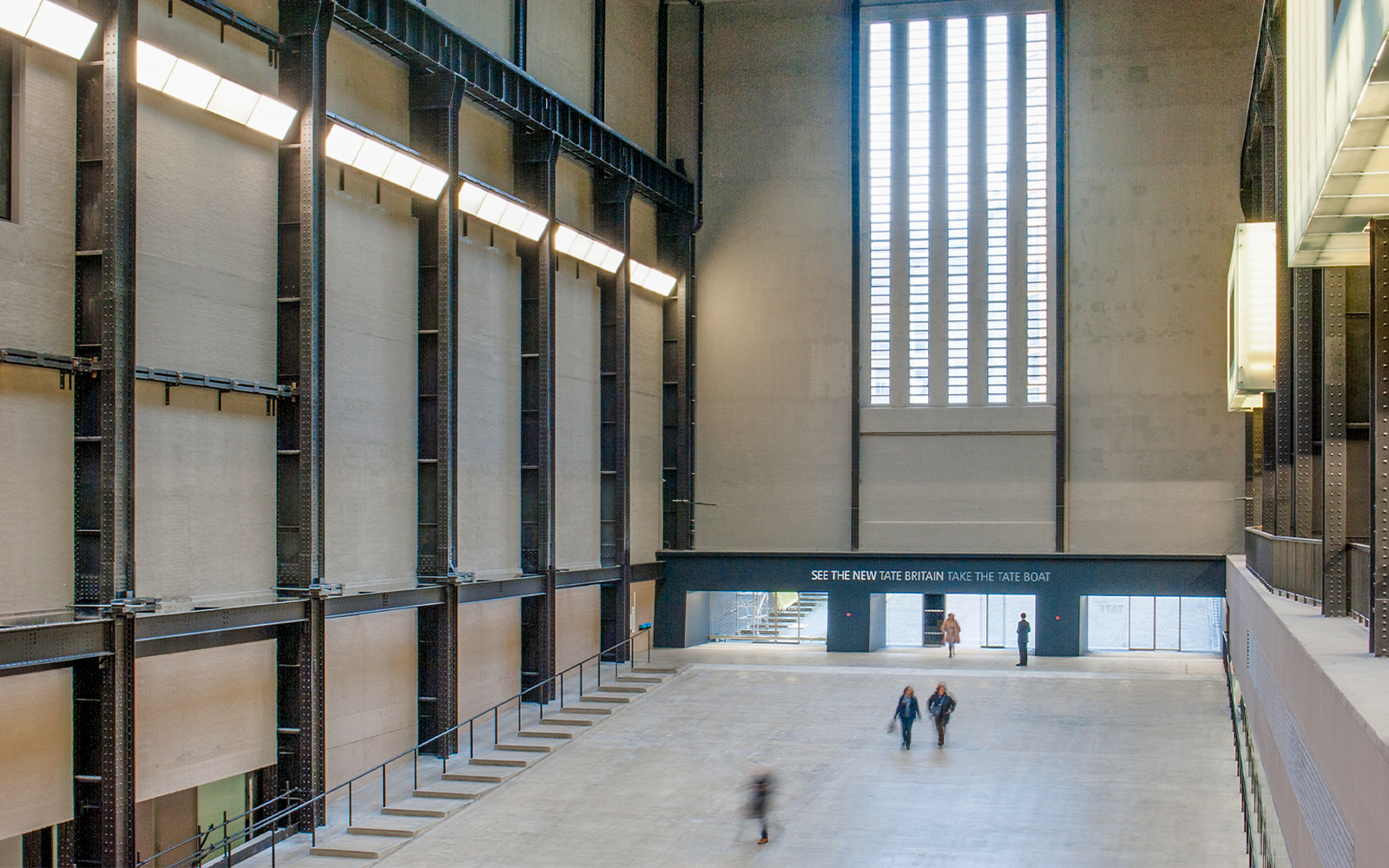 Turbine Hall interior at Tate Modern, London, with visitors walking through the spacious gallery.