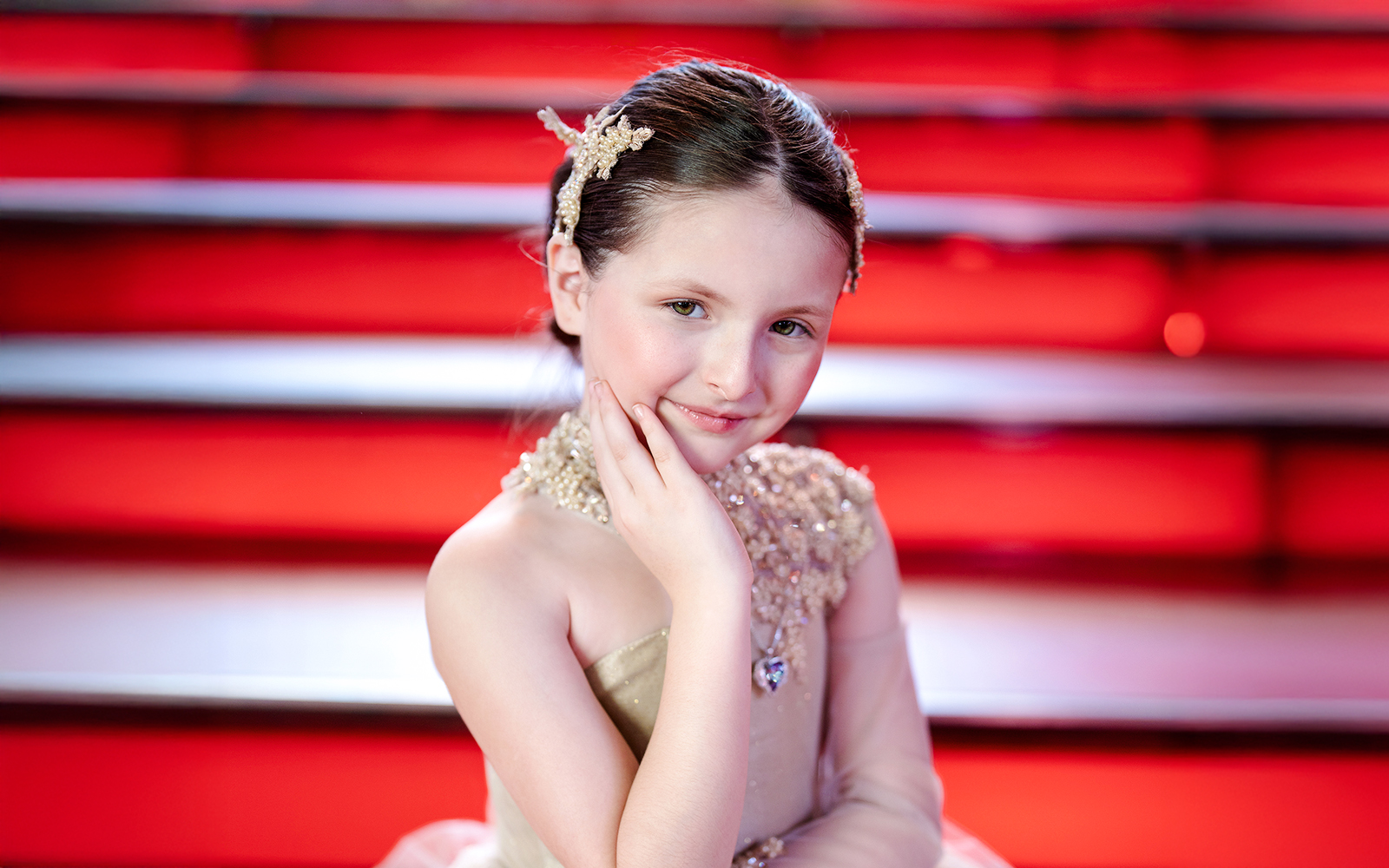 Girl posing at Times Square with red steps in the background.