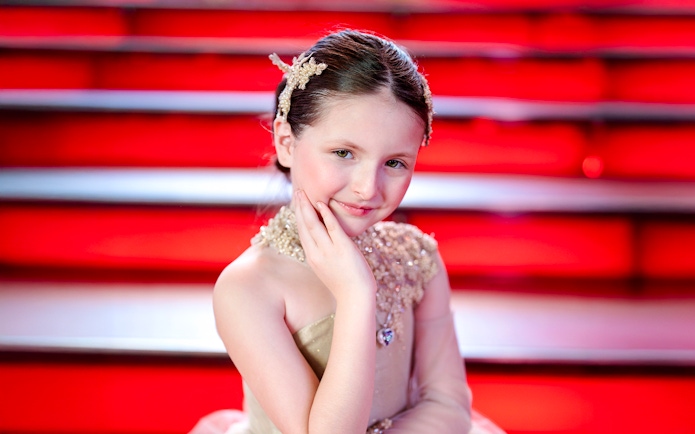 Girl posing at Times Square with red steps in the background.