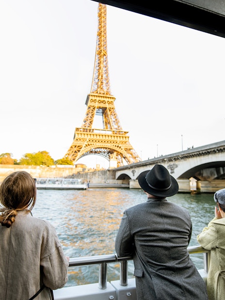 Tourists on Seine River Cruise viewing Eiffel Tower in Paris.