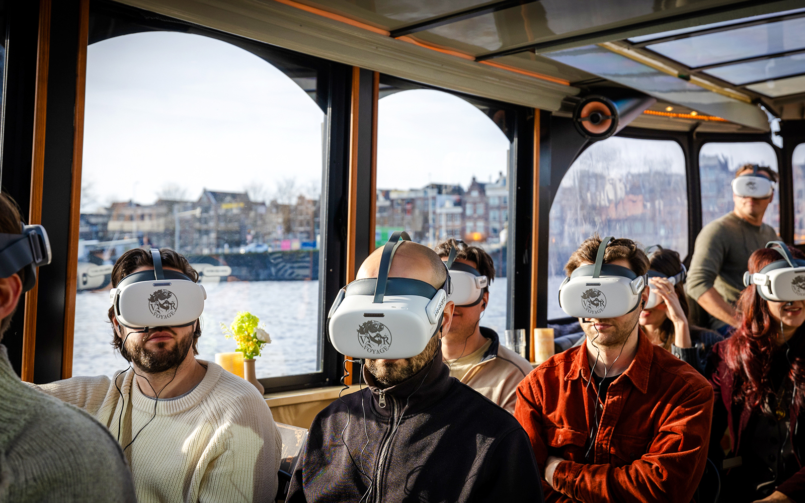 People wearing VR headsets on a luxury boat tour in Amsterdam.