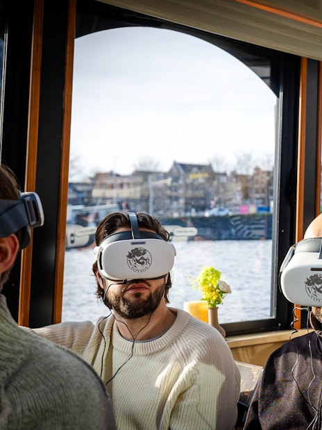 People wearing VR headsets on a luxury boat tour in Amsterdam.