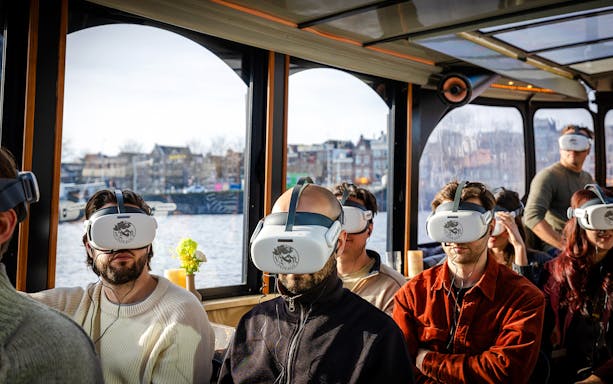 People wearing VR headsets on a luxury boat tour in Amsterdam.