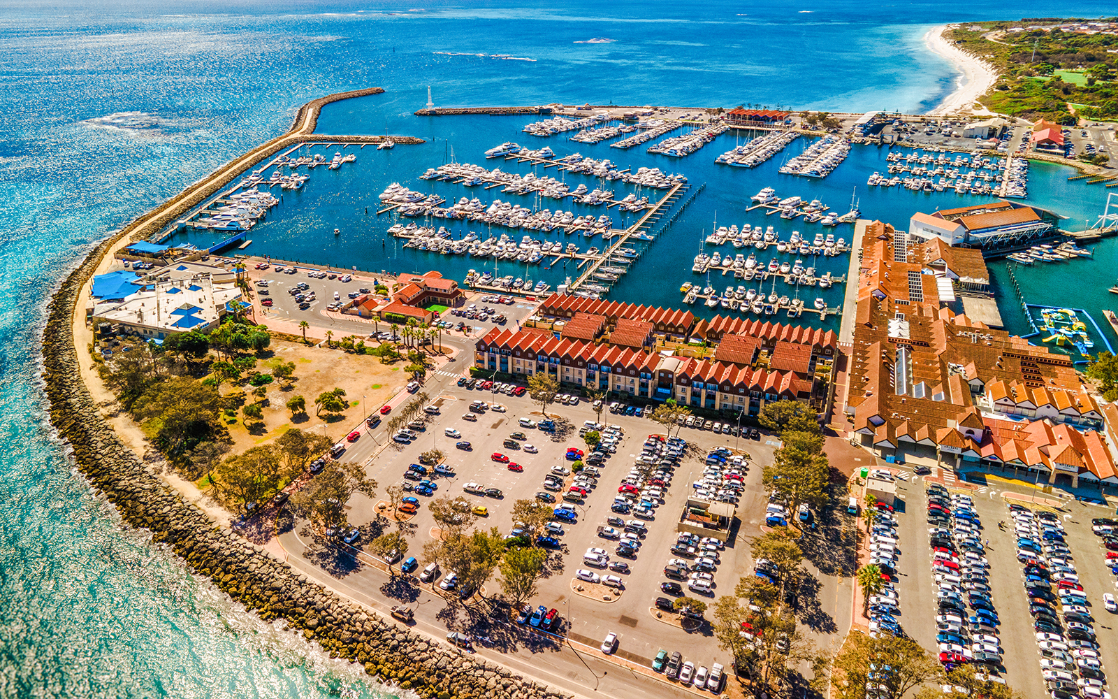 Aerial view of Hillarys Boat Harbour marina with yachts and waterfront buildings, Australia.