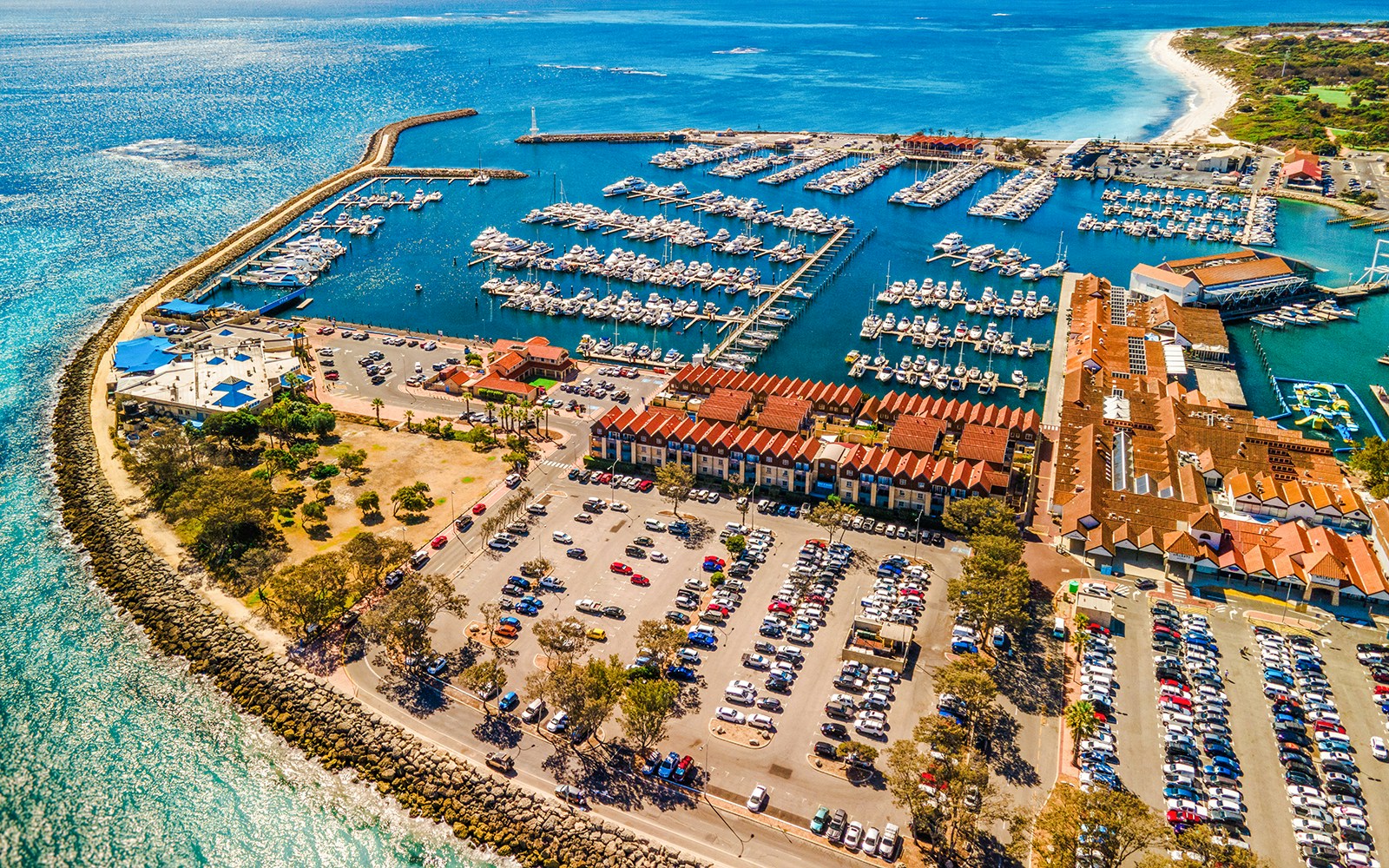 Aerial view of Hillarys Boat Harbour marina with yachts and waterfront buildings, Australia.