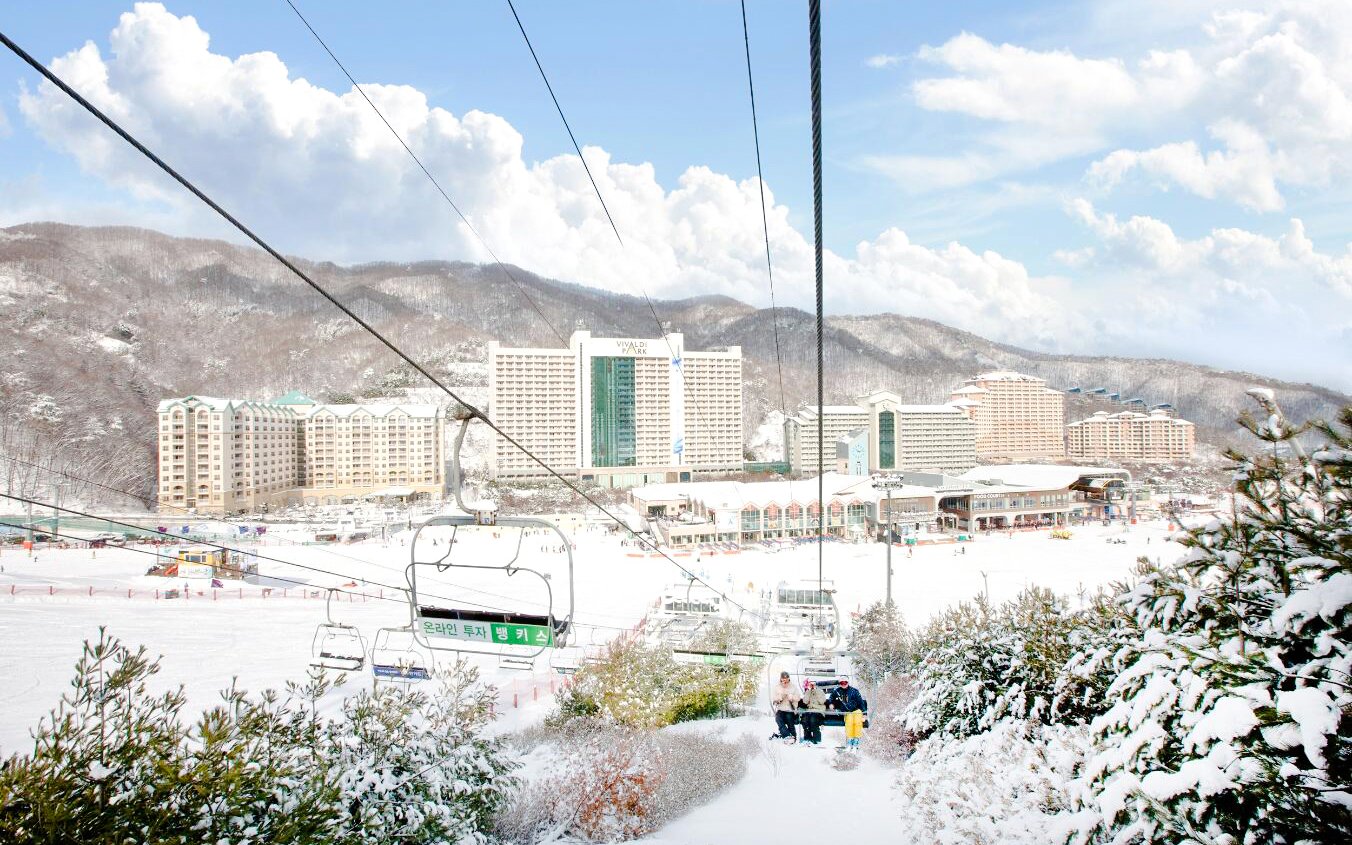 Gondola ride over snowy Vivaldi Park Ski World with resort view.