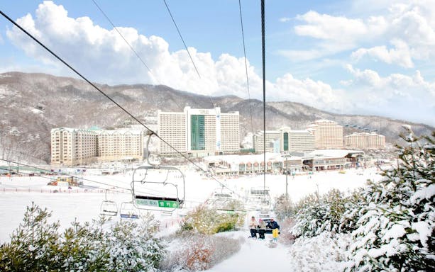 Gondola ride over snowy Vivaldi Park Ski World with resort view.