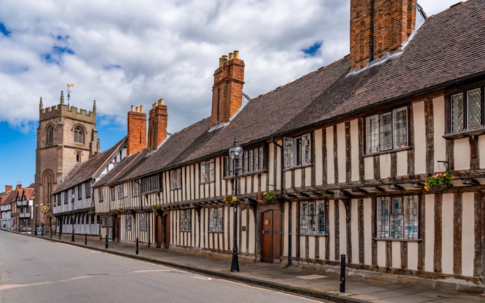 Historic half-timbered buildings and church tower in Stratford Upon Avon.