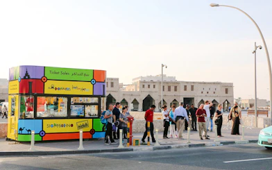 Doha Bus ticket kiosk with tourists at Souq Waqif, Qatar.