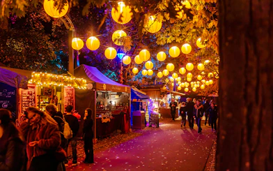 Heide Park Halloween market with lanterns and food stalls at night.