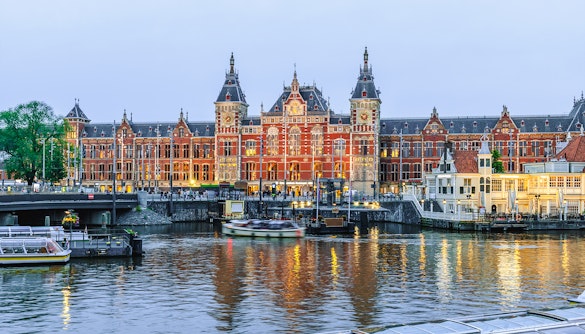 Amsterdam Centraal station with canal boats in North Holland, Netherlands.