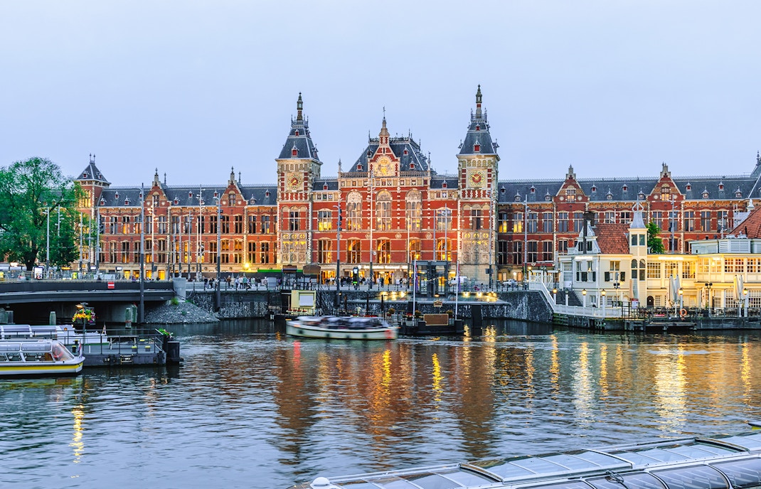 Amsterdam Centraal station with canal boats in North Holland, Netherlands.
