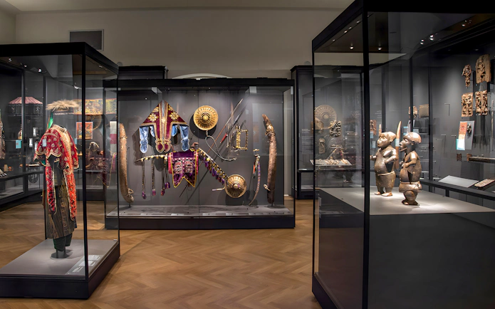 Exhibits of cultural artifacts and traditional attire at Weltmuseum Vienna.