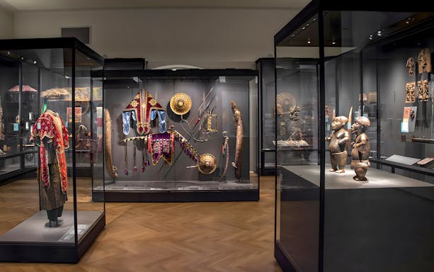 Exhibits of cultural artifacts and traditional attire at Weltmuseum Vienna.