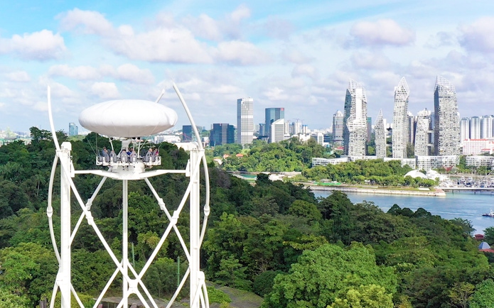 SkyHelix Sentosa ride with panoramic view of Singapore skyline and lush greenery.