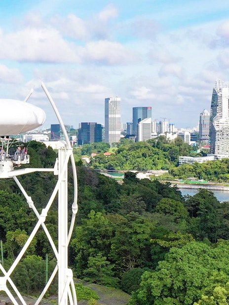 SkyHelix Sentosa ride with panoramic view of Singapore skyline and lush greenery.