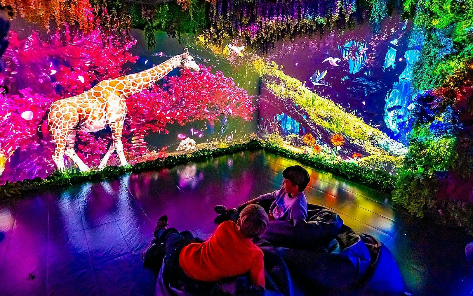Children in the Magic Room at Big Fun Museum, Barcelona, watching a vibrant giraffe projection.