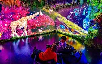 Children in the Magic Room at Big Fun Museum, Barcelona, watching a vibrant giraffe projection.