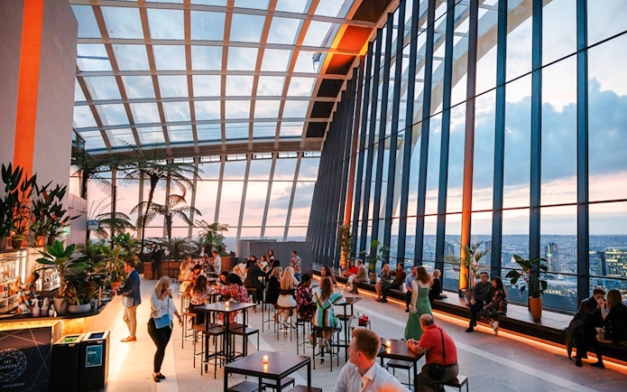 Guests enjoying the view at Sky Garden London during sunset.