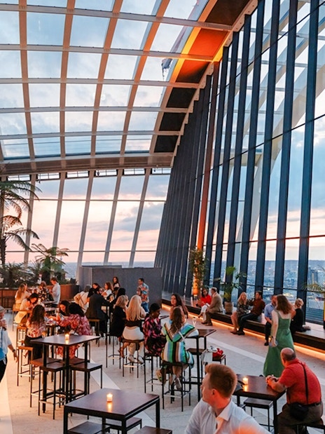 Guests enjoying the view at Sky Garden London during sunset.