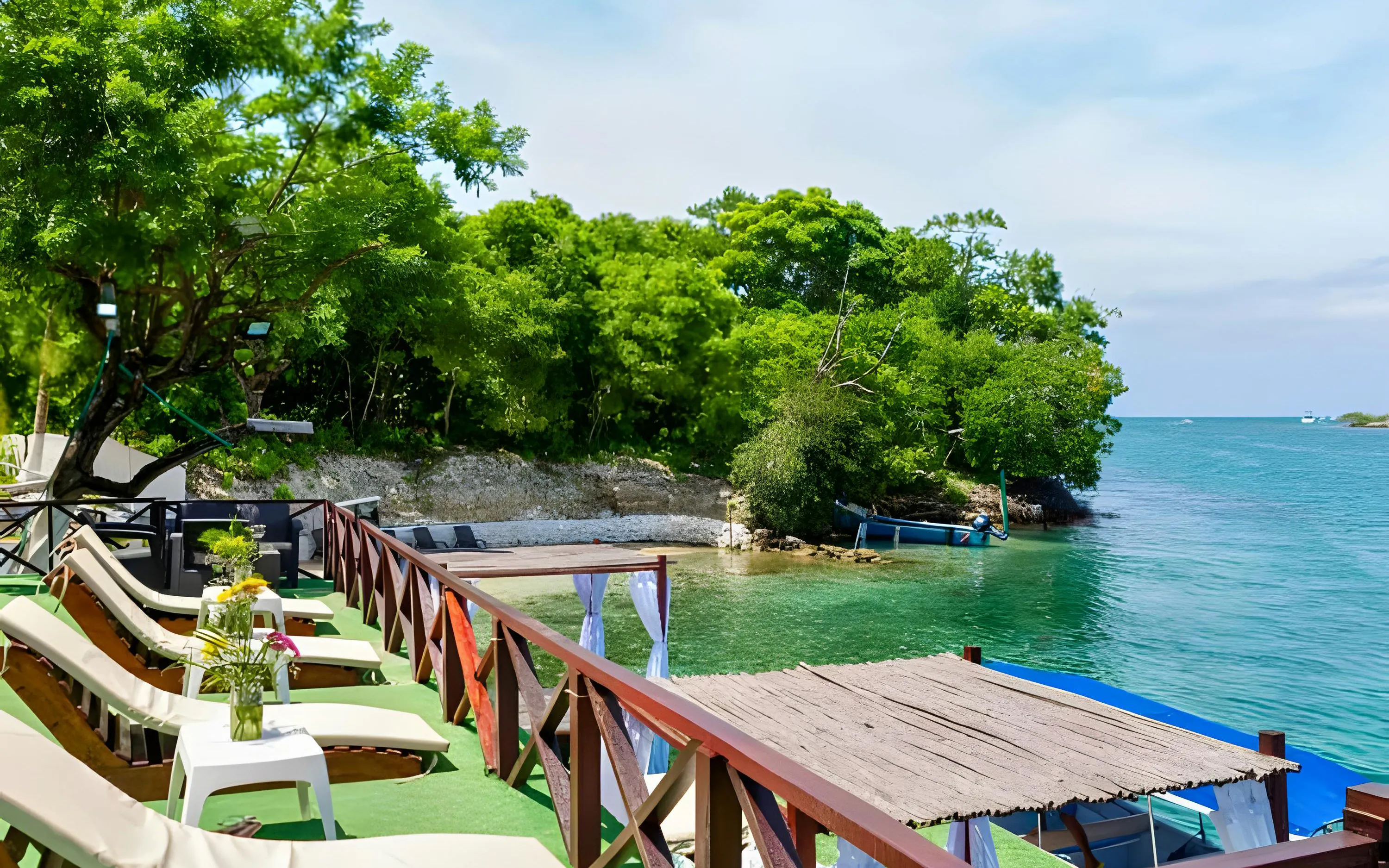 Deck with lounge chairs overlooking clear blue water of Rosario Island, Cartagena, Colombia.