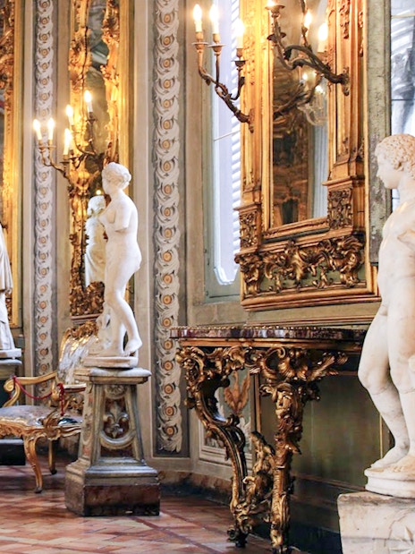 Girl exploring ornate hall with statues at Doria Pamphilj Gallery, Rome.