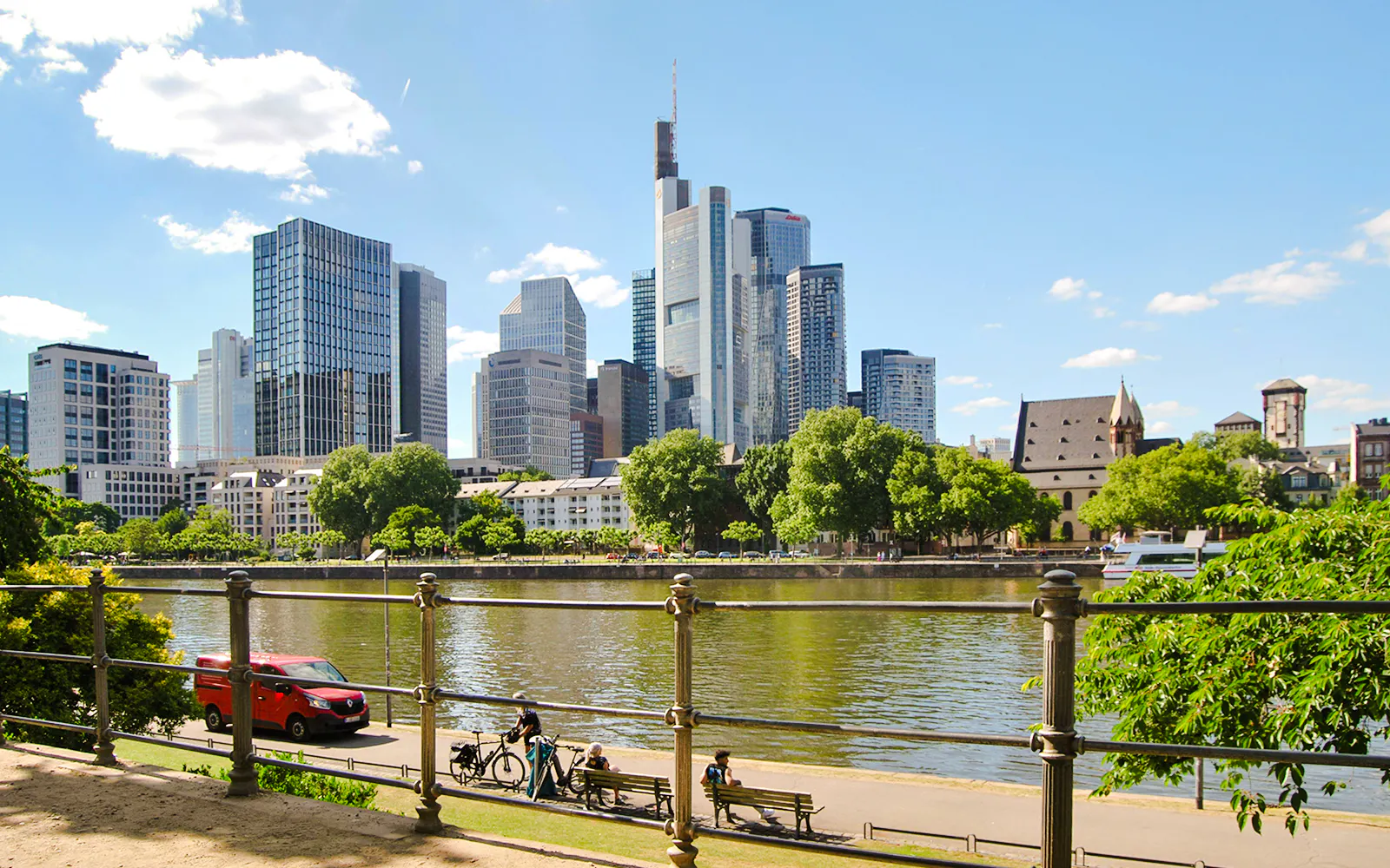 Skyline of Frankfurt am Main with skyscrapers and riverfront walkway.