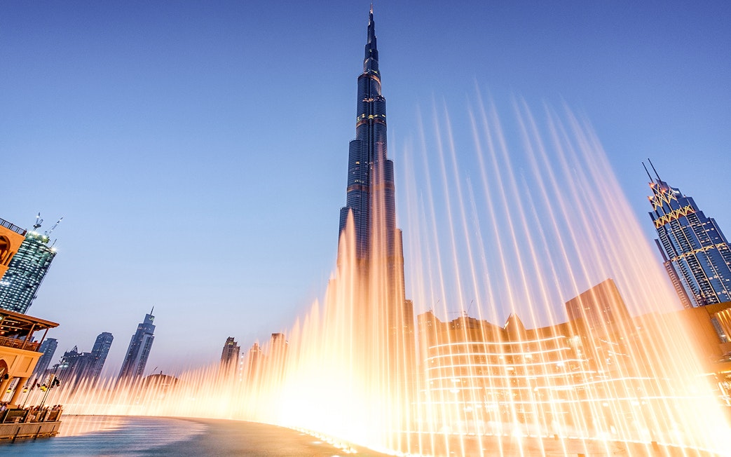 Dubai Fountain Boardwalk with Burj Khalifa in the background at dusk.