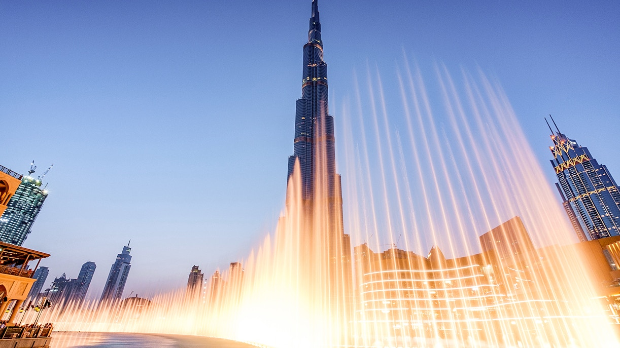 Dubai Fountain Boardwalk with Burj Khalifa in the background at dusk.