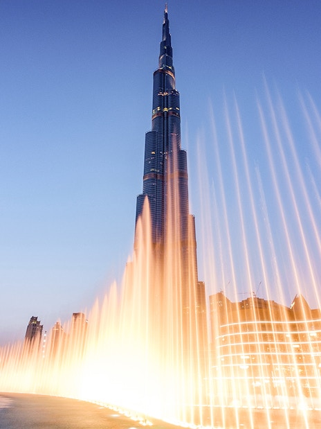 Dubai Fountain Boardwalk with Burj Khalifa in the background at dusk.