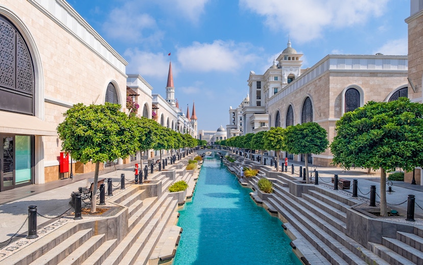 Wild river ride at Land of Legends Theme Park with canal and architectural buildings.